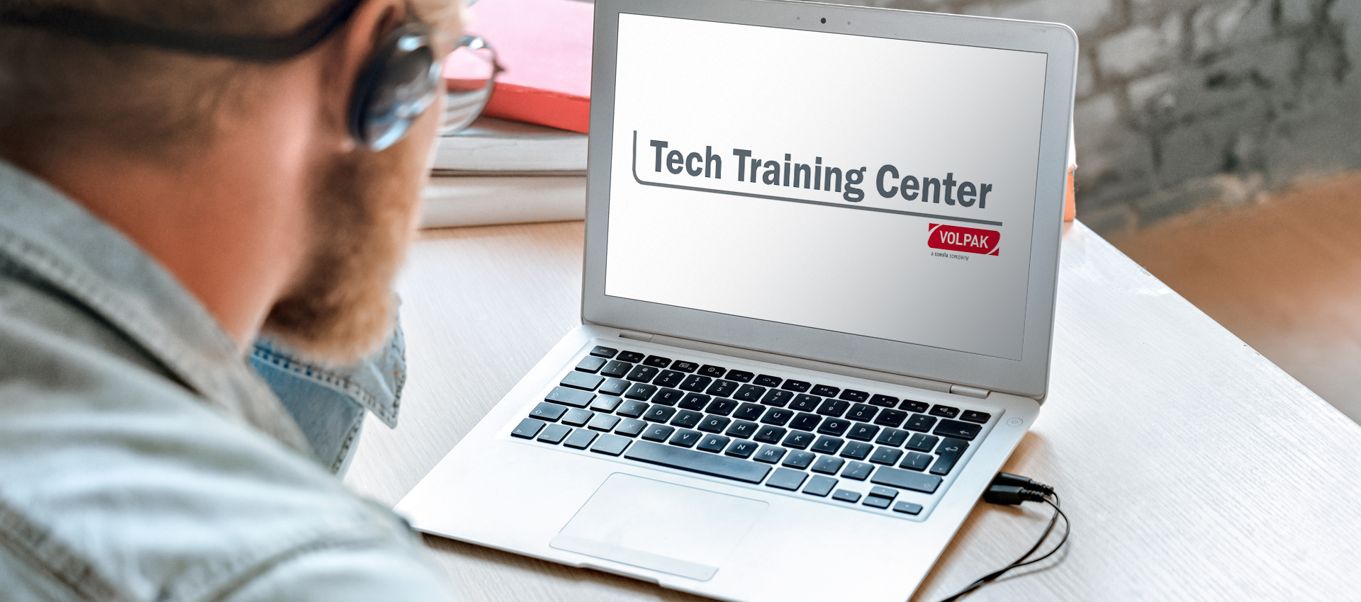 Man looking at his computer screen at the Volpak Tech Training Center online campus. 